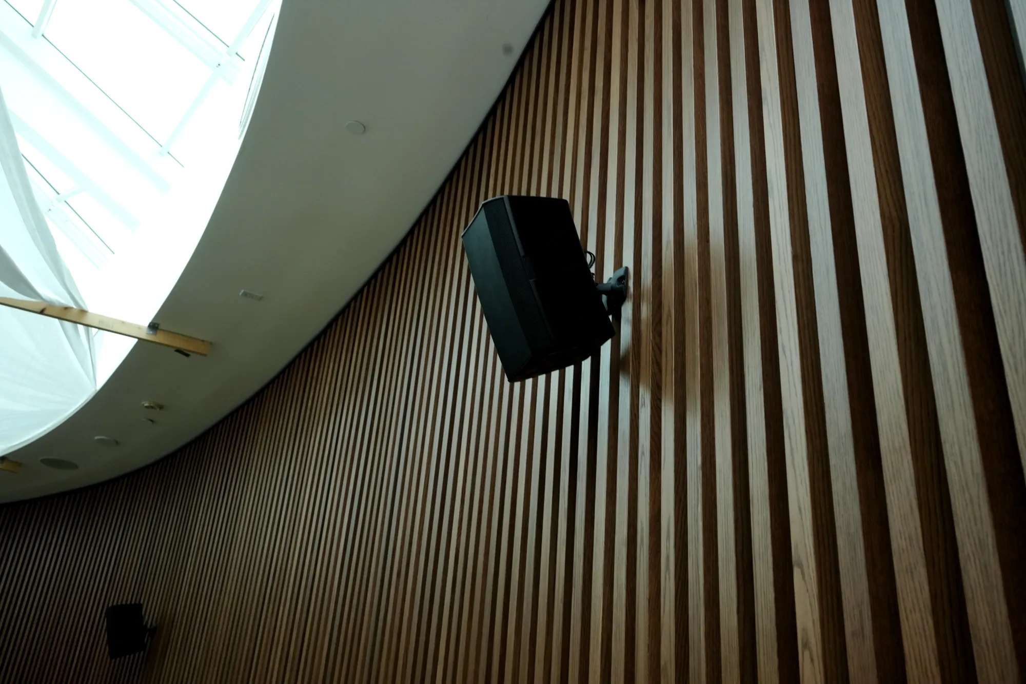 Loudspeaker mounted on a wood slat wall, installed by DIST in New York