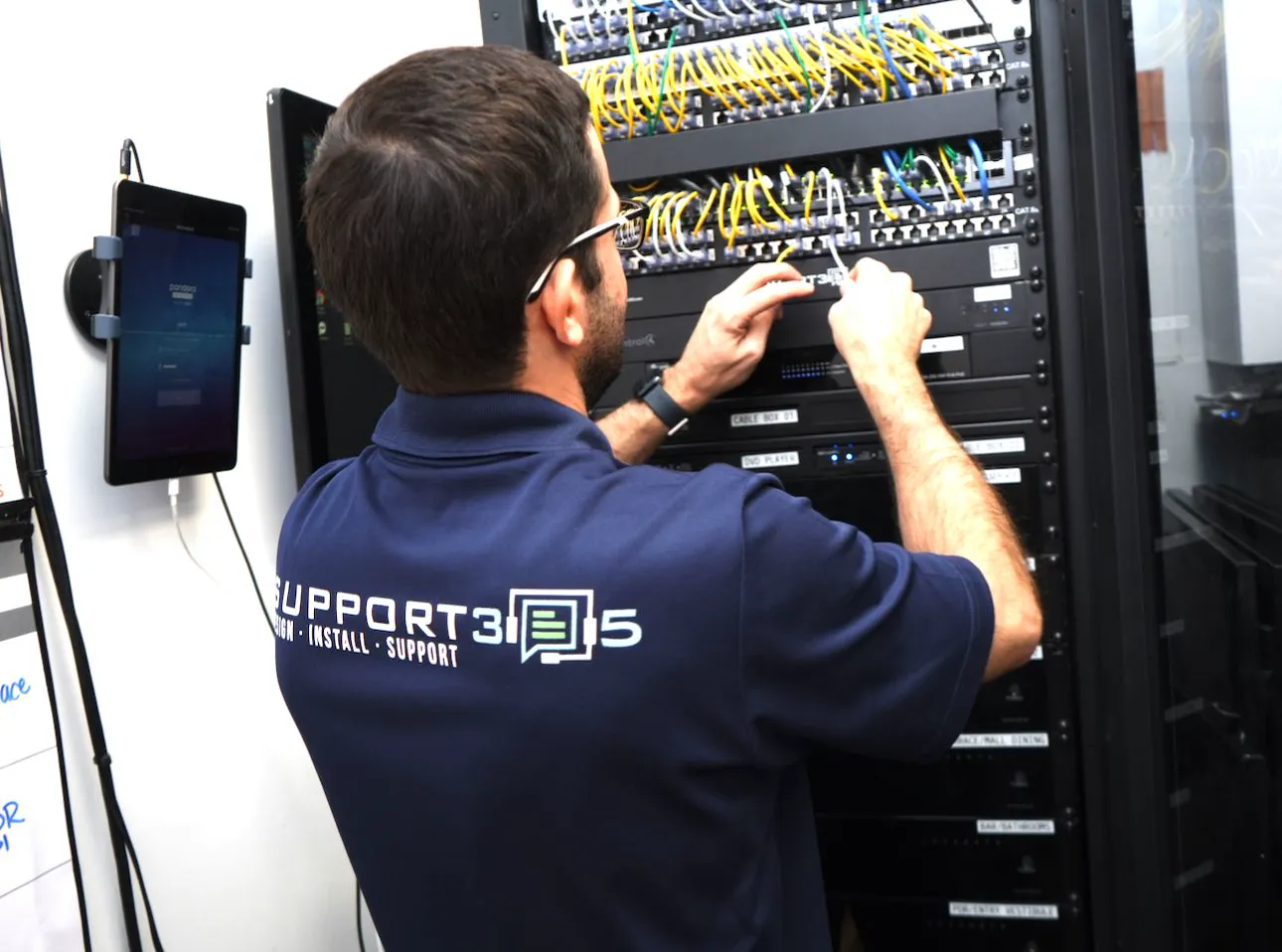 Technician patching an AV rack